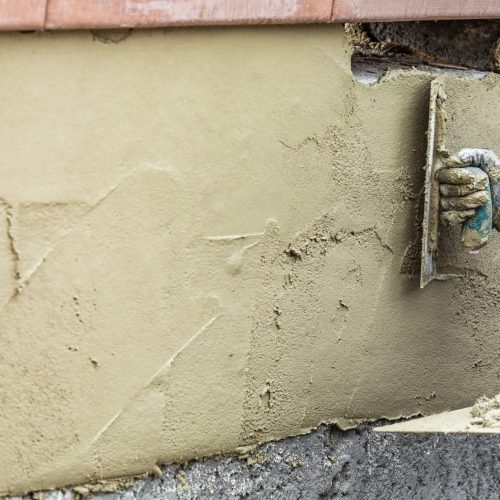 Tile Worker Applying Cement with Trowel at Pool Construction Site.
